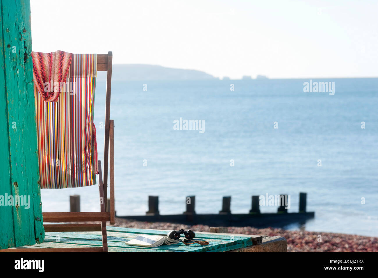 Empty deck chair by beach Stock Photo