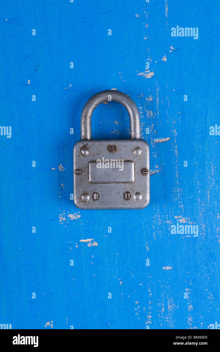 Old fashion silver padlock on a textured blue wooden background Stock Photo