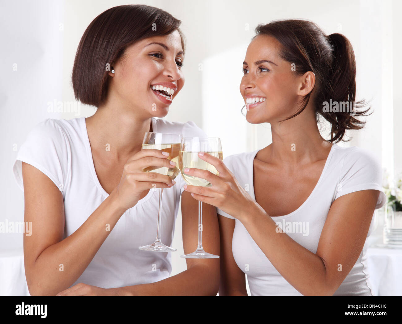 TWO WOMEN DRINKING WHITE WINE Stock Photo