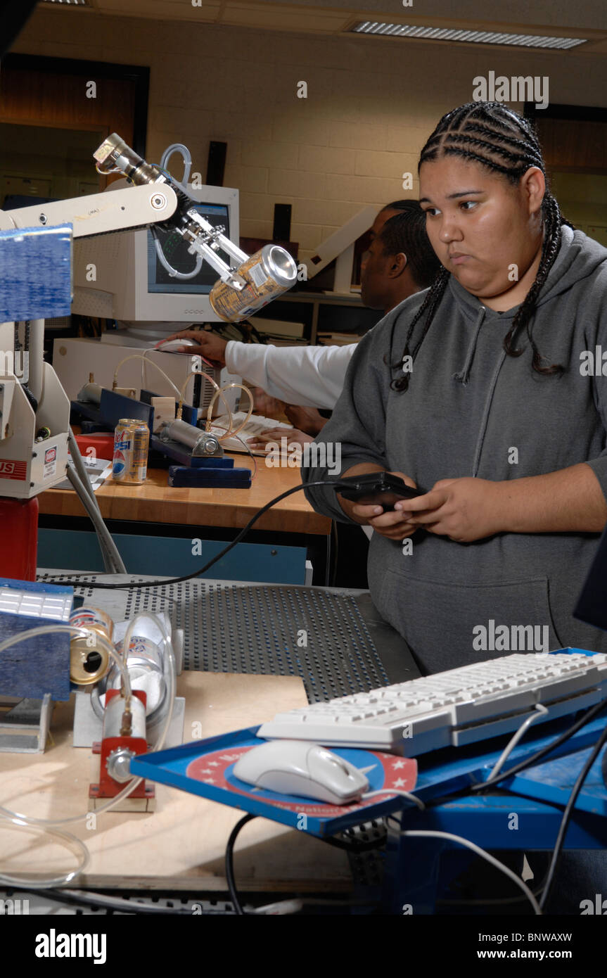 Hispanic female student at Carver Magnet High School operates a student-designed and built robotic can crusher Stock Photo