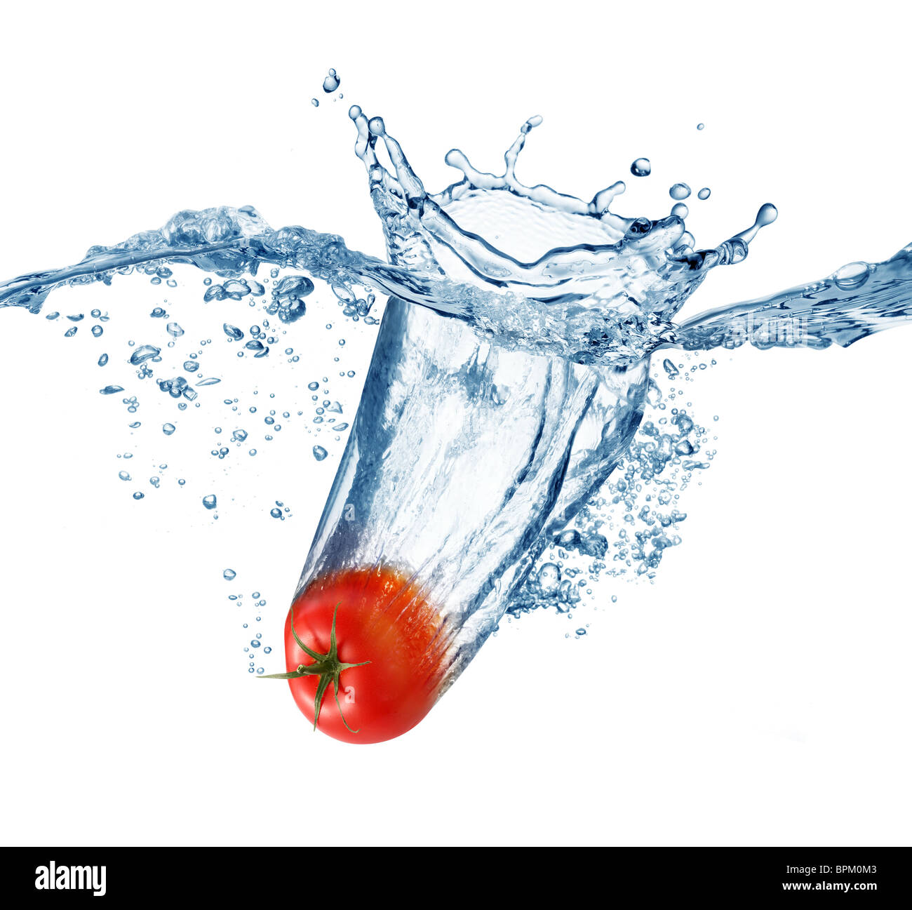 Ripe tomato falls deeply under water with a big splash. Stock Photo