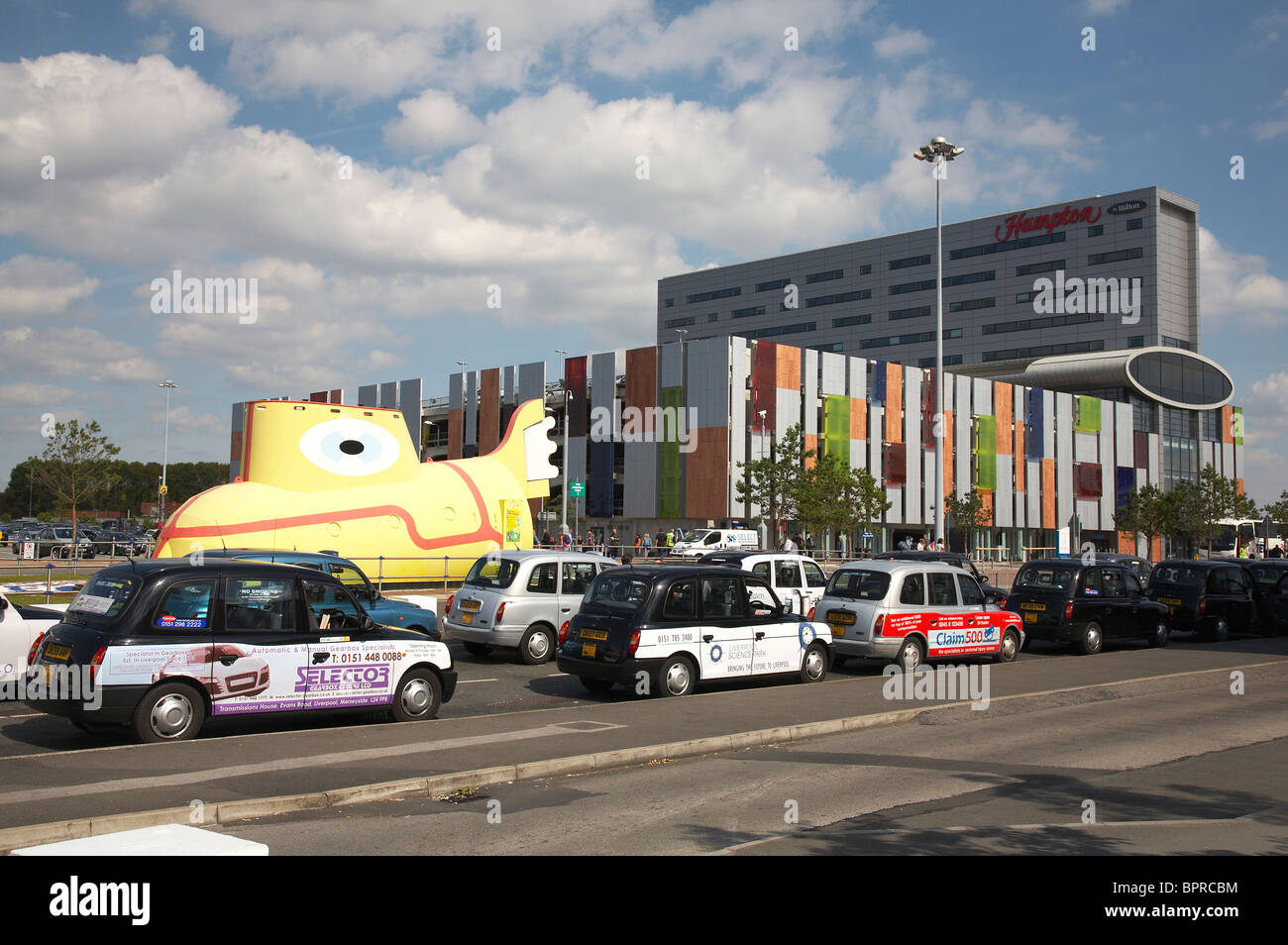 Hampton by Hilton hotel with Yellow submarine and multistorey carpark at John Lennon Airport Liverpool UK Stock Photo