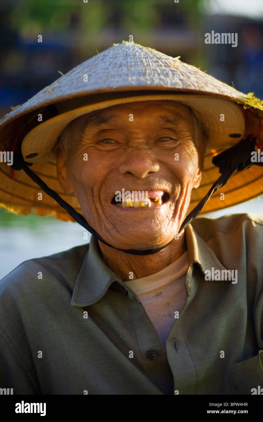 A gold-toothed Vietnamese man smiles while resting on the Thu Bon River, Hoi An, Vietnam. Indochina. Southeast Asia. Jan 2010 Stock Photo