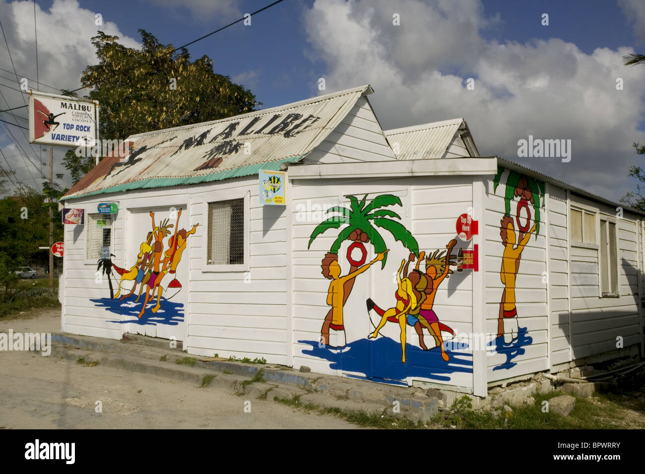 White with colourful beach scene painted on the exterior the Malibu Rum Shop near Oistins Stock Photo