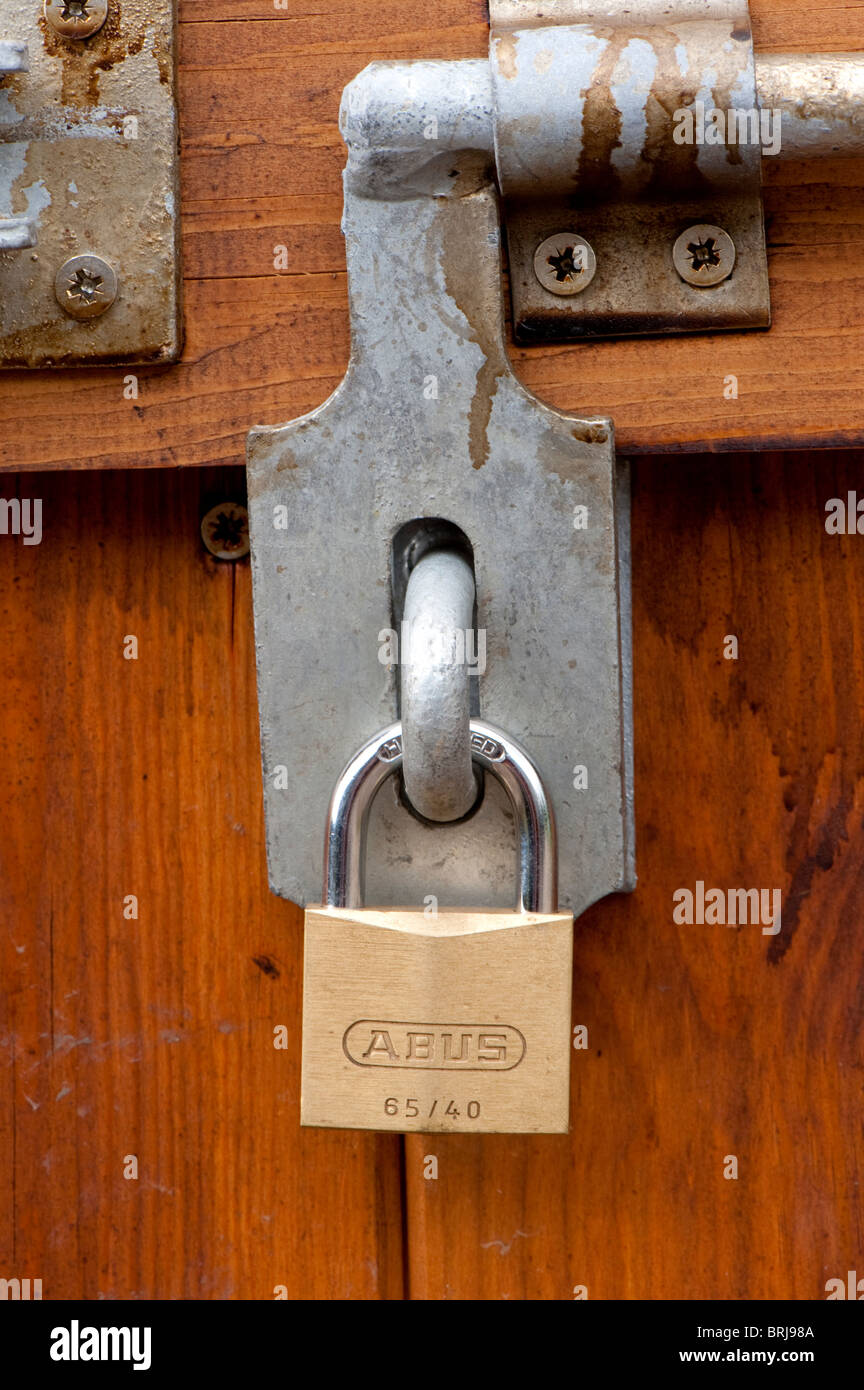 Padlock and bolt on a wooden door Stock Photo