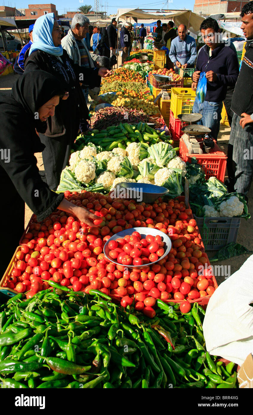 Muslim women buy fruit and vegetables at the local market Stock Photo