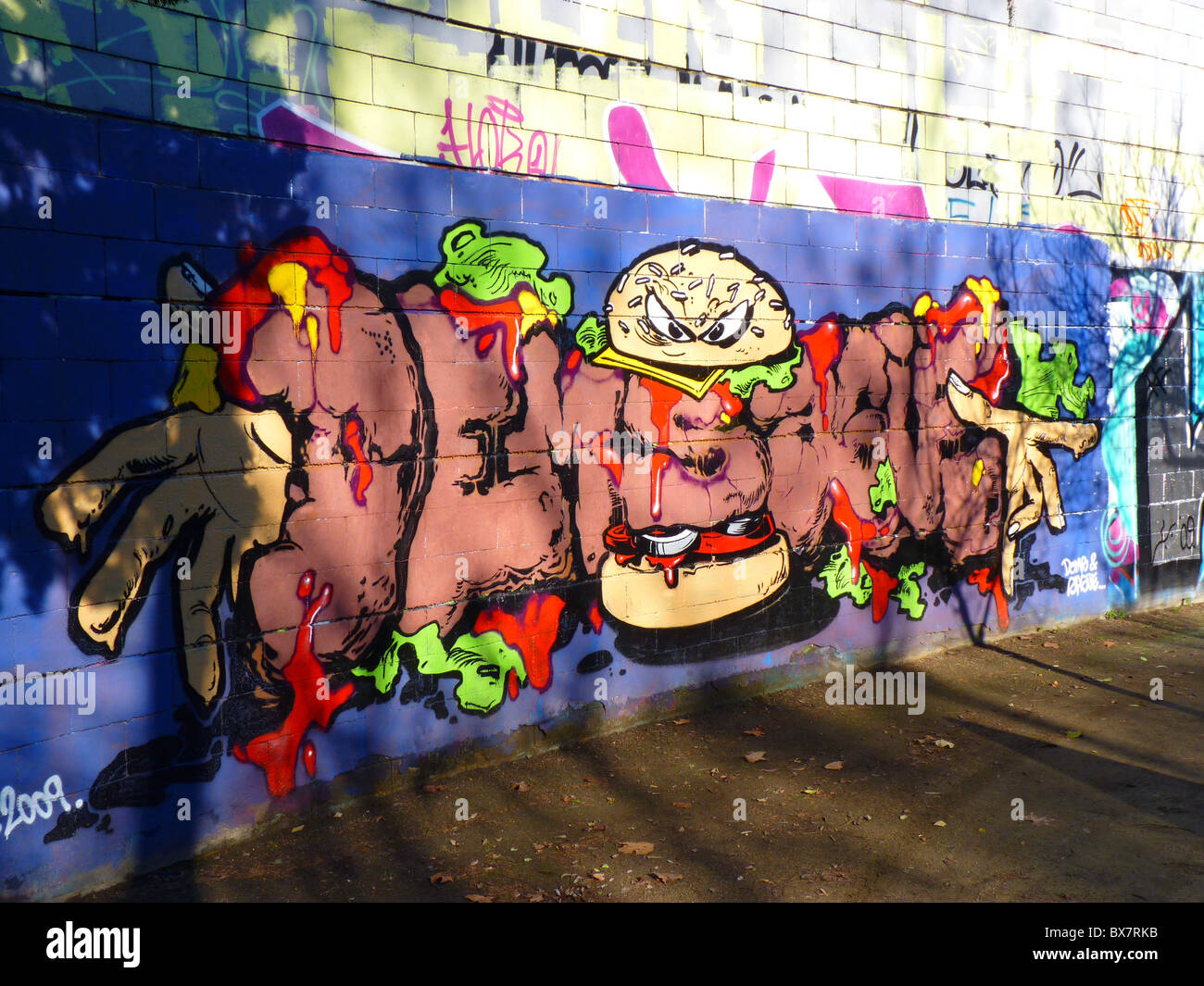 Art crimes: Large mural on wall of public park in Barcelona Spain-- graffiti as street art and gang markings Stock Photo