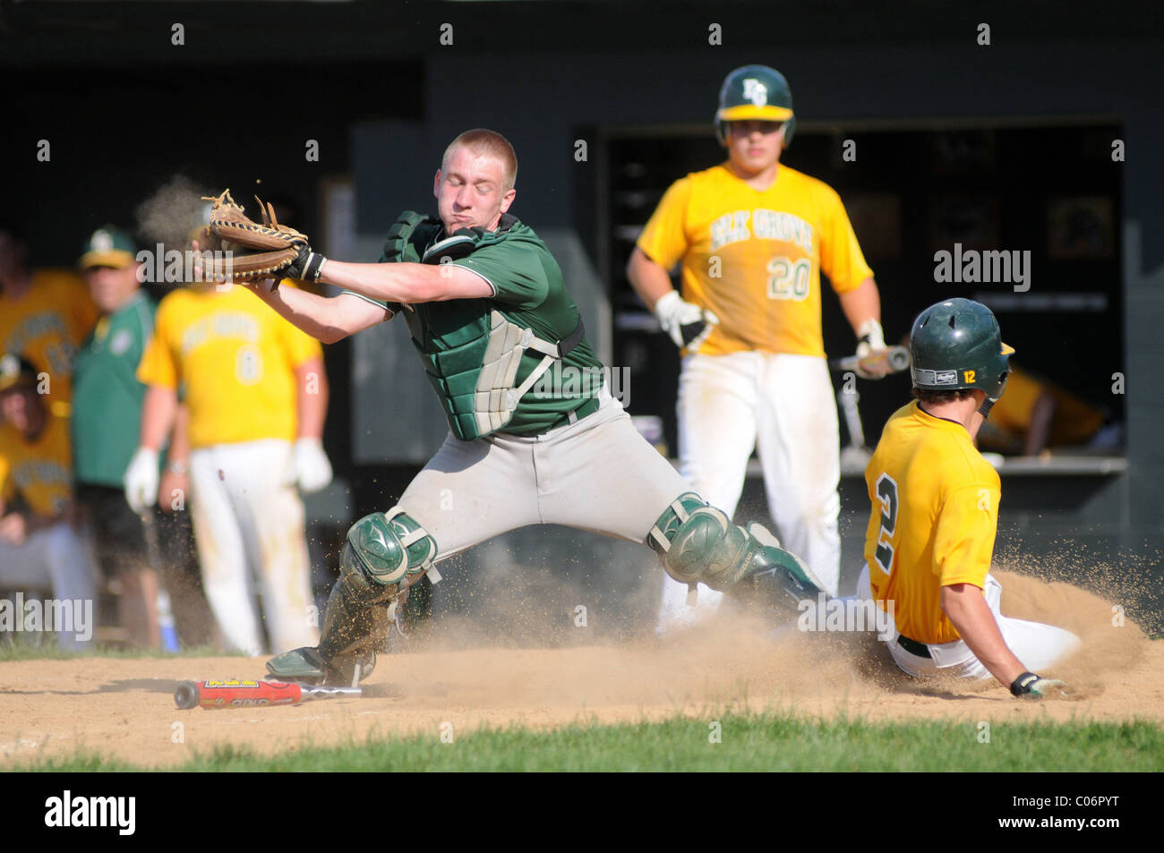 Catcher extends to catch the throw while trying to block the runner while the runner slides away from a possible tag. USA. Stock Photo