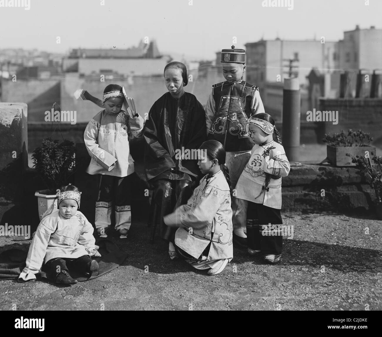 Chinese Mother with her children in Native Costume sit on rooftop Stock Photo