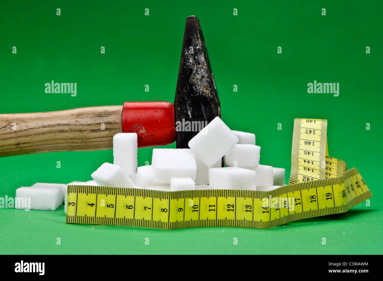 a hammer which is disturbing sugar cubes for a healthier nutrition in the future Stock Photo