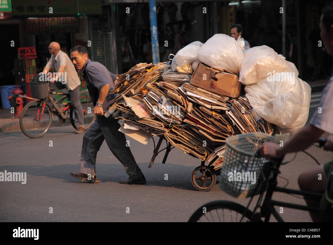 Man pulls cart full of recyclables, Guangzhou, China Stock Photo