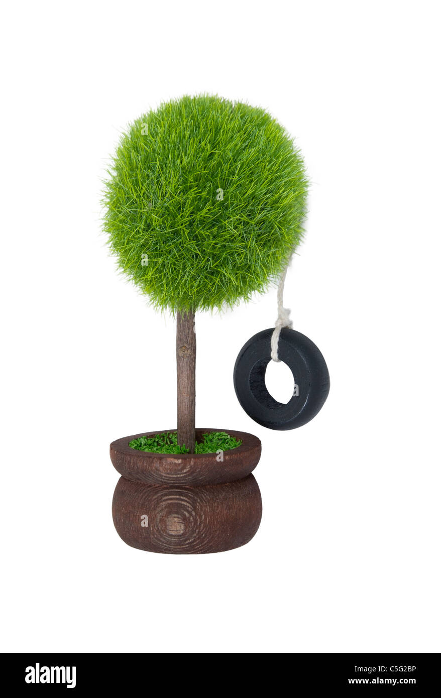 Tire swing hanging from a potted tree reminiscent of childhood - path included Stock Photo