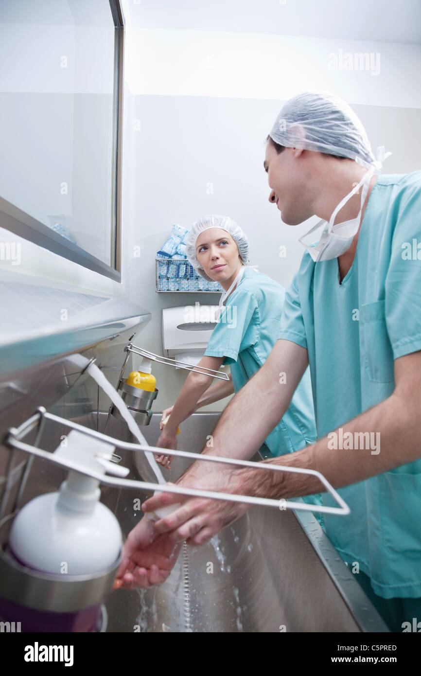 Young surgeons washing hands while talking after operation Stock Photo ...