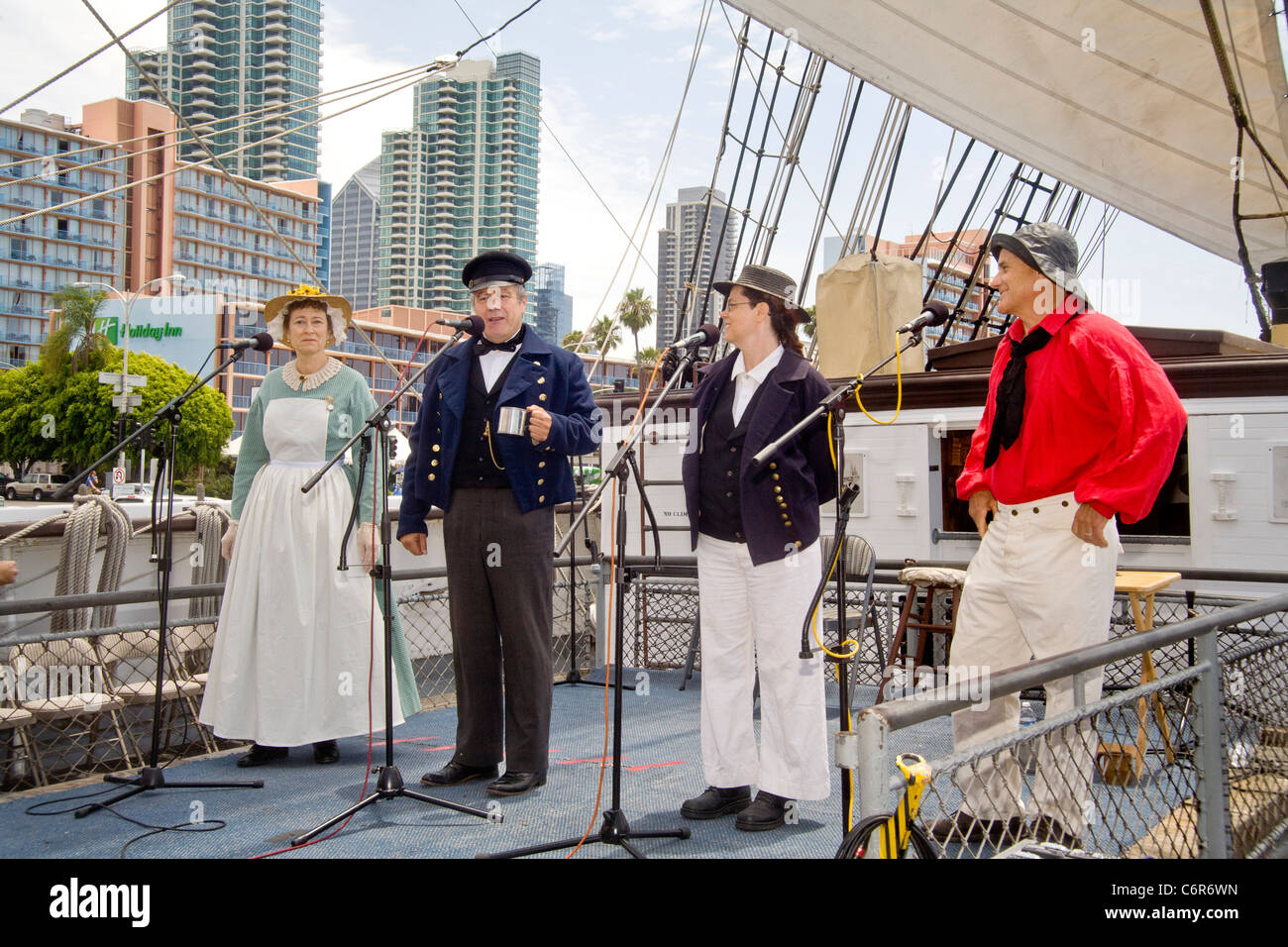 Wearing 19th Century nautical costumes, the singing group Flash Packet performs a sea chantey on the sailing ship Star of India. Stock Photo