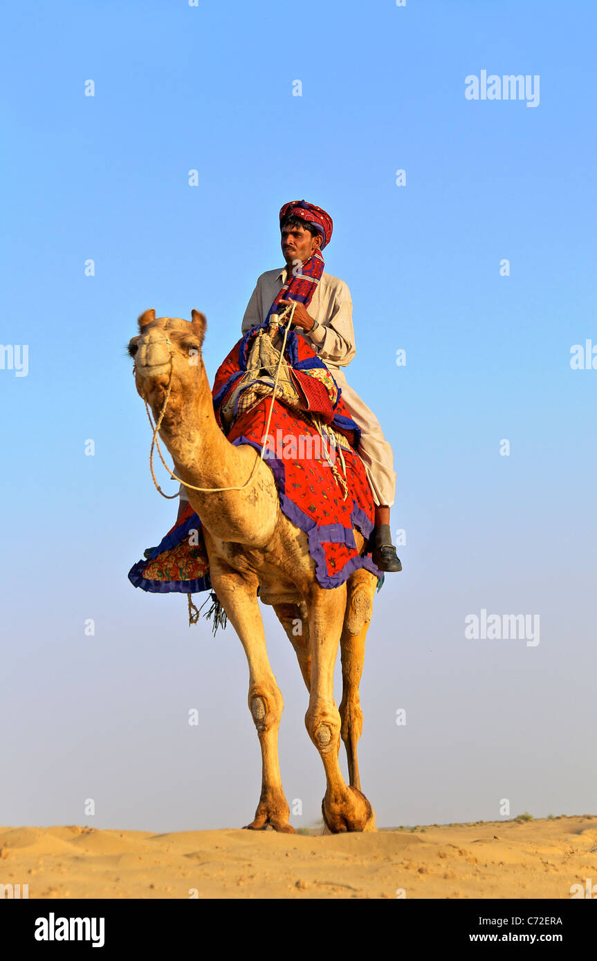 Camel owner riding camel Sam Dunes Desert National Park Western Rajasthan India Stock Photo