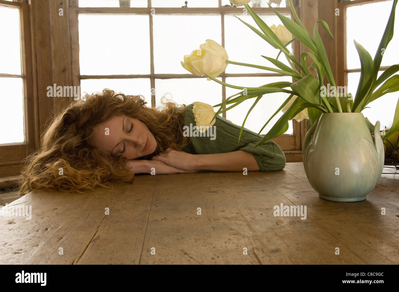 Woman sleeping on kitchen table Stock Photo