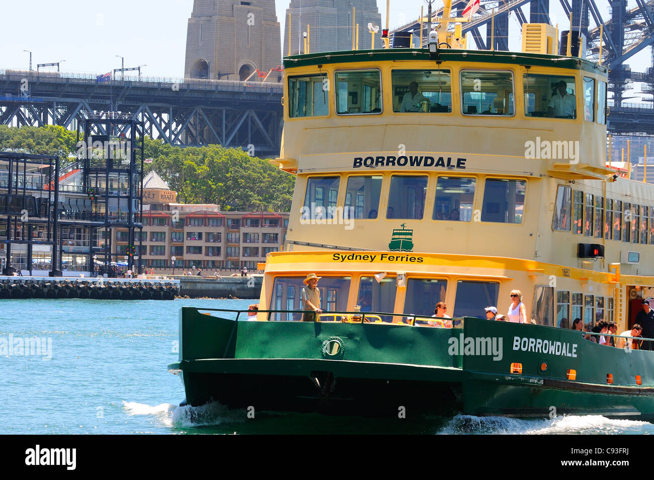 Sydney Ferry coming into Circular Quay terminal with Sydney Harbour bridge Overseas Passenger Terminal, Park Hyatt Hotel in view, Australia Stock Photo