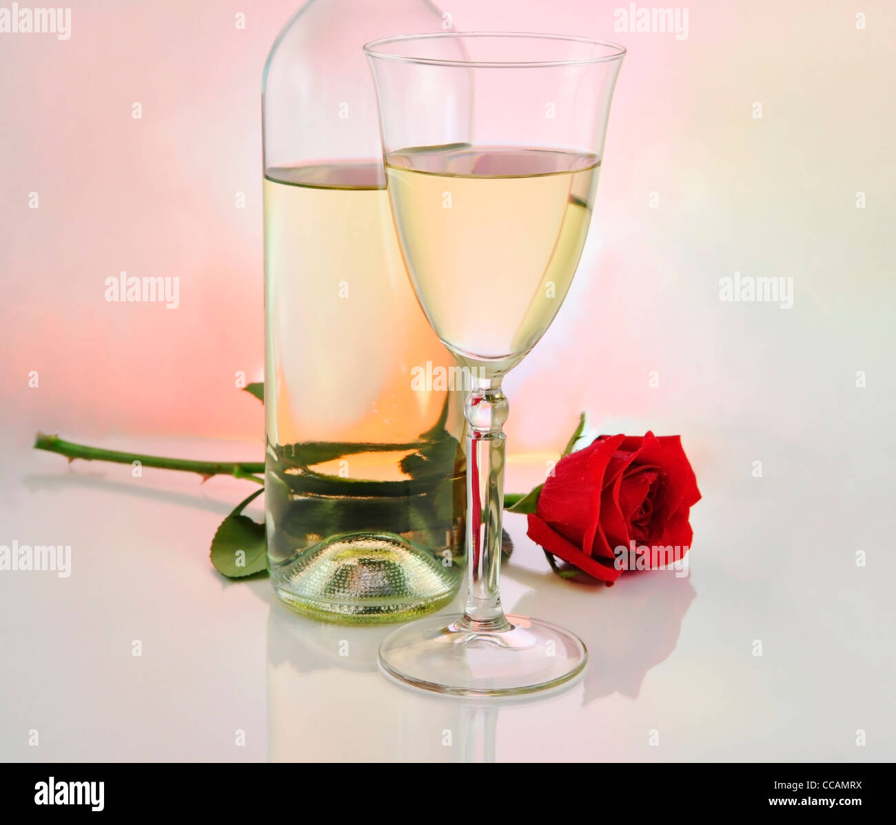 a glass of white wine with bottle and rose Stock Photo