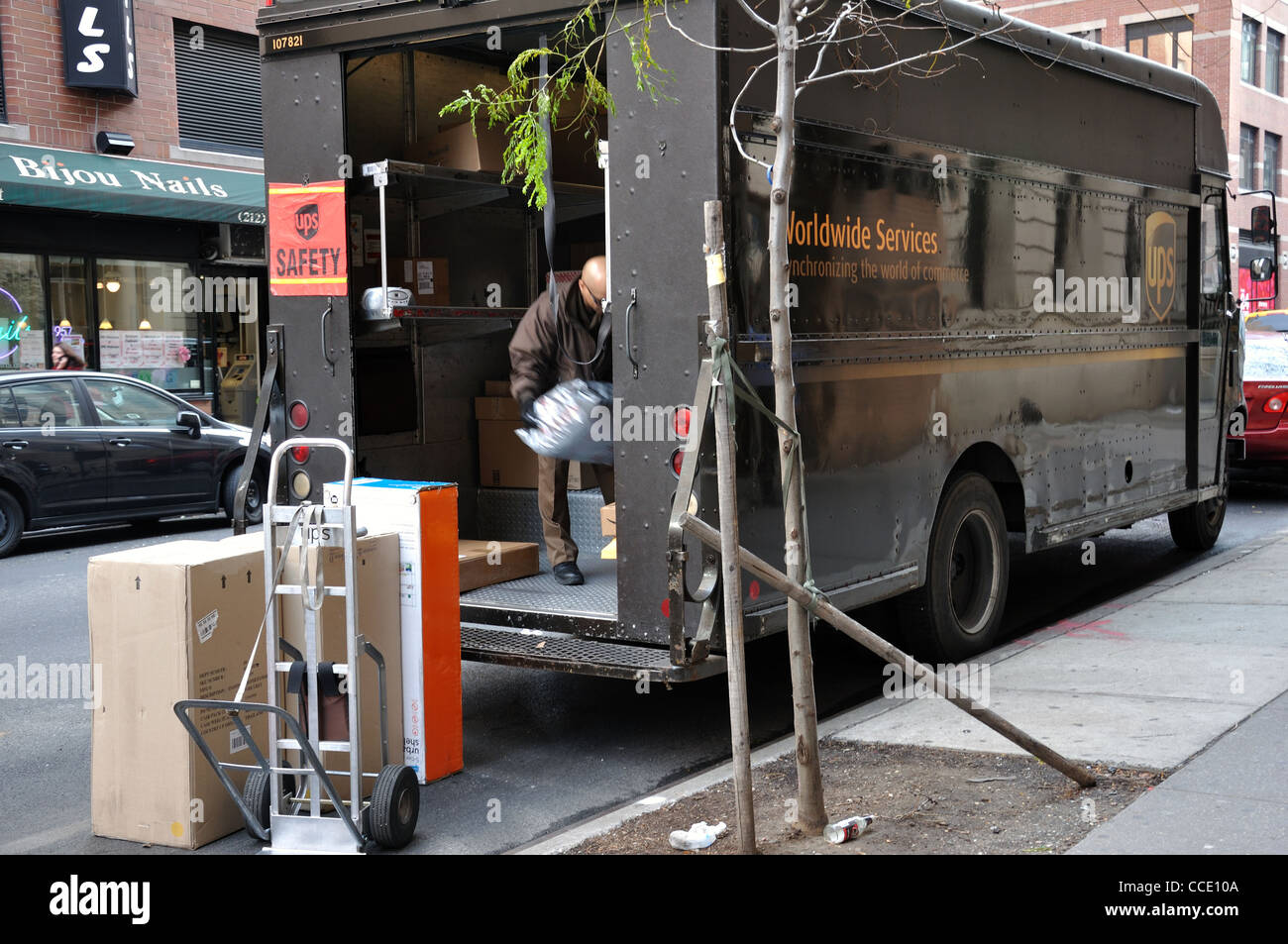 UPS truck and driver unloading it, Manhattan, New York City, USA Stock Photo