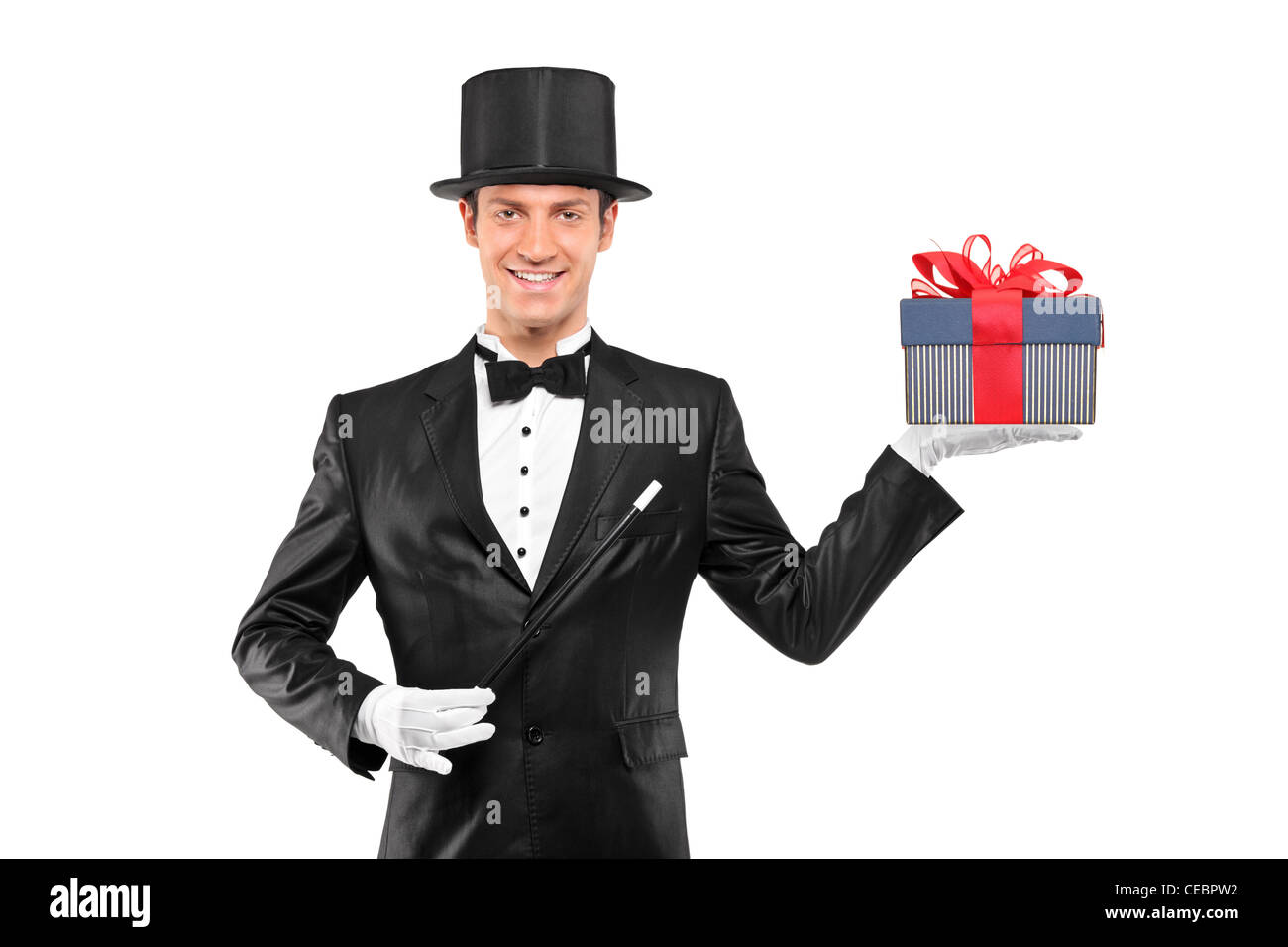 Young magician holding a magic wand and a gift isolated against white background Stock Photo