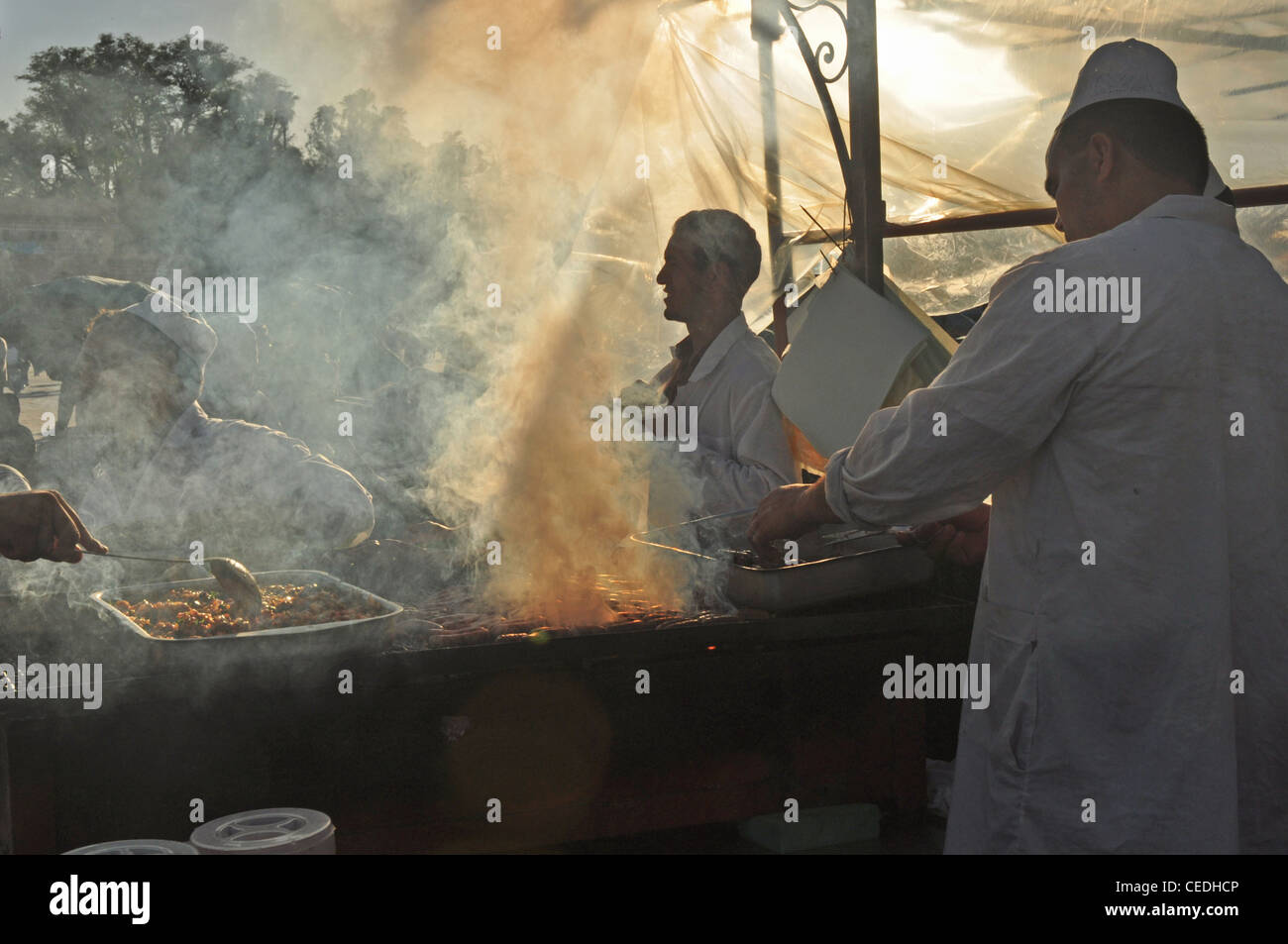 NORTH AFRICA, MOROCCO, MARRAKESH, Djemaa el-Fna (main square), stalls with mist from cooking meat - in strong sunlight Stock Photo