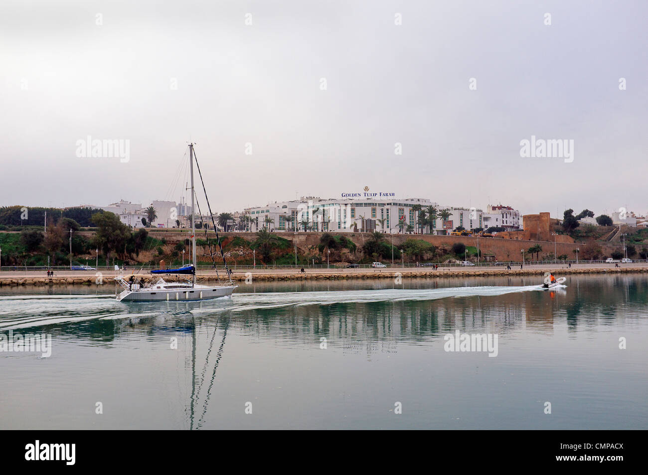 Yacht leaving the Bouregreg Marina Salé with the Golden Tulip Farah hotel Rabat in background, Bou Regreg river, Morocco Stock Photo