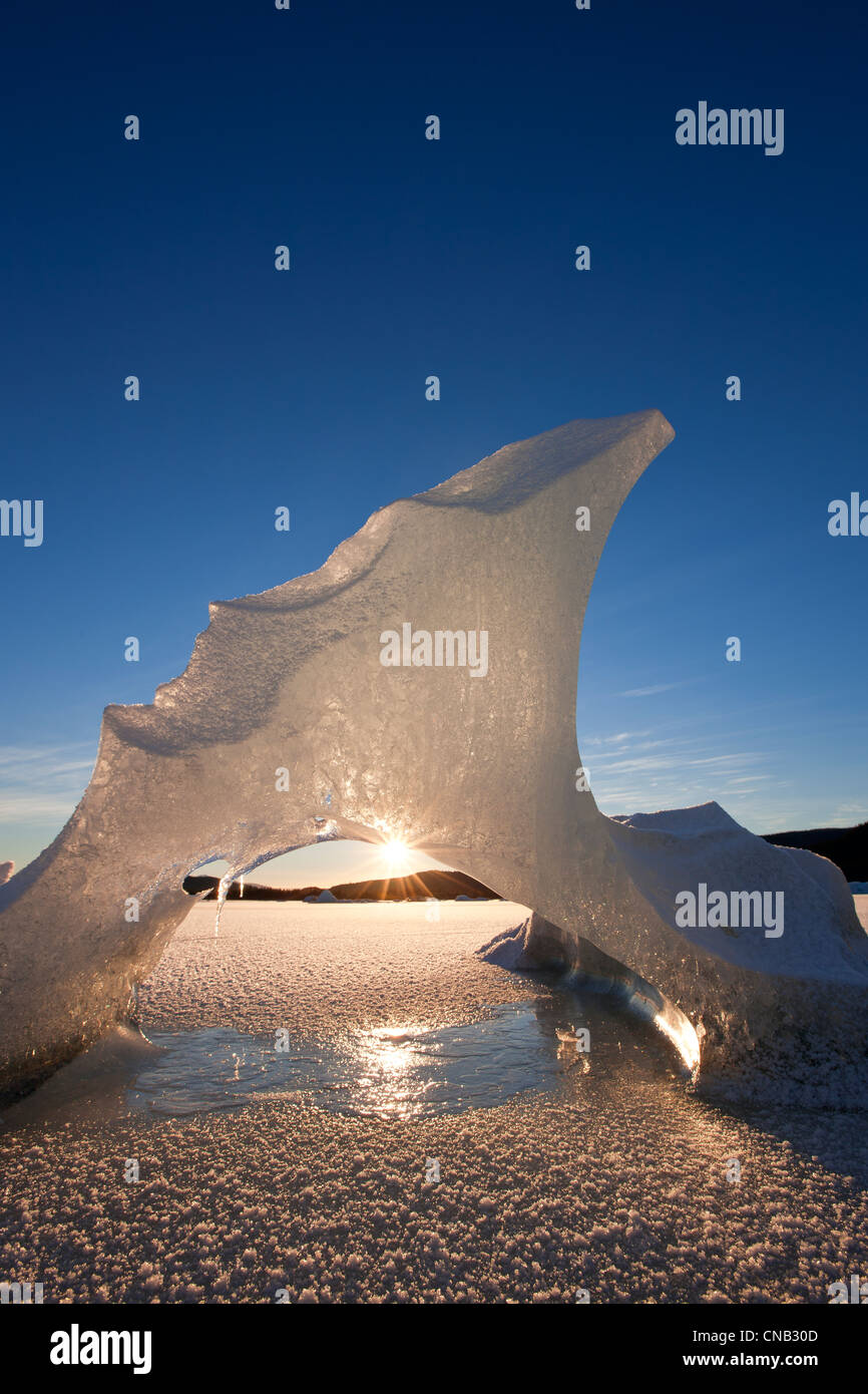 View of icebergs formations frozen in Mendenhall Lake with sun peeking through, Tongass National Forest, Alaska, Winter Stock Photo