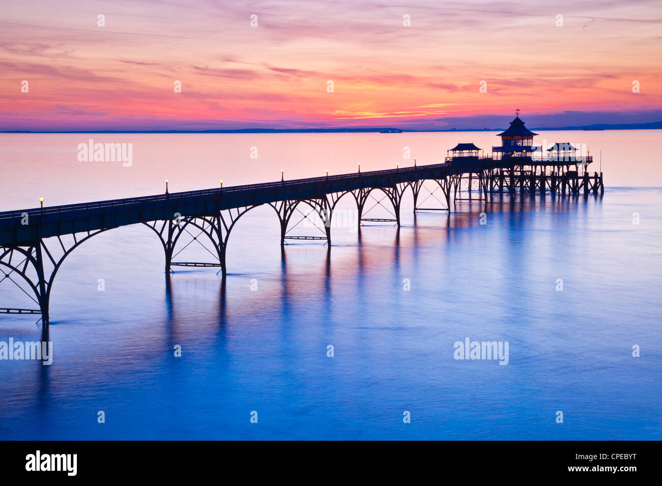 The sun sets over the Bristol Channel behind the Pier at Clevedon, Somerset, England, UK Stock Photo