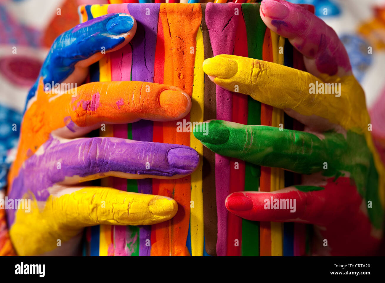 Close-up of woman holding multicolored paint can with painted fingers Stock Photo