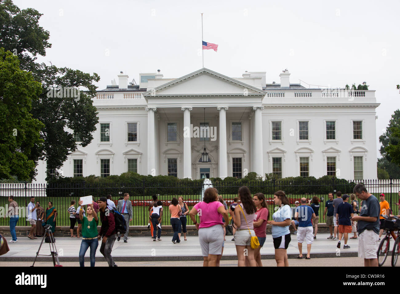 The White House with its flag lowered to half mast. Stock Photo