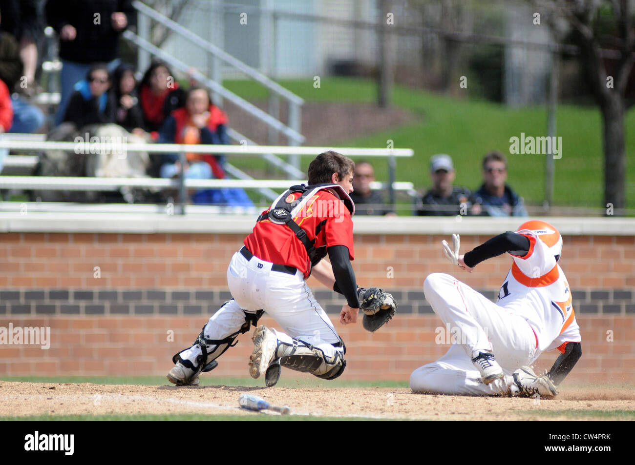 Baseball high school catcher applying a tag to a sliding runner to record an out at the plate. USA. Stock Photo