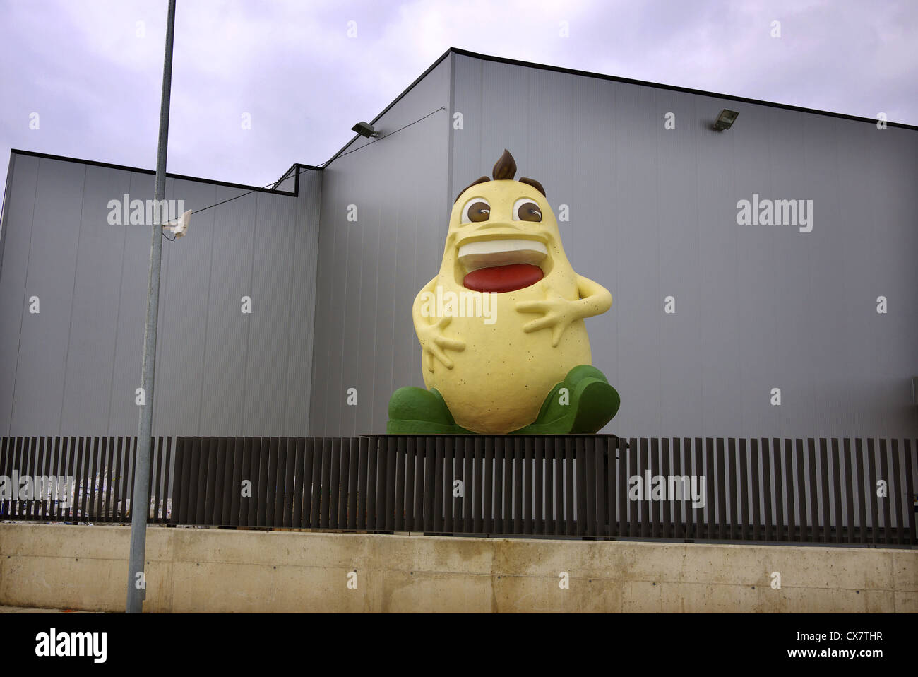 Caricature of a laughing cartoon peanut outside a factory in Spain. Stock Photo