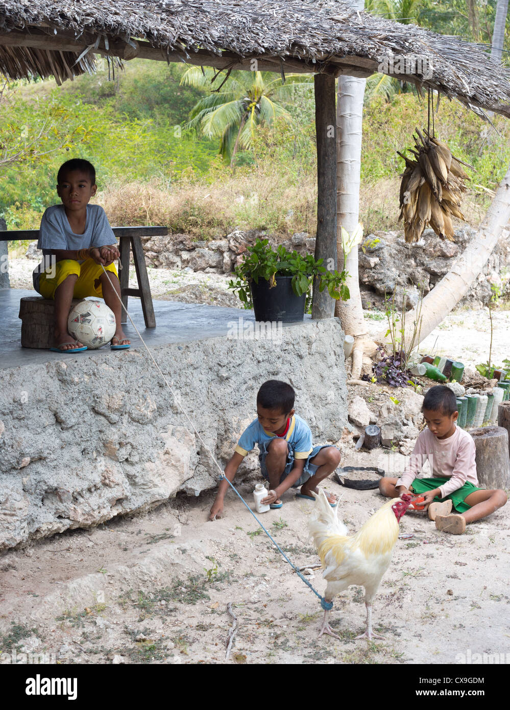 Young boys sitting outside a traditional house, Baucau, East Timor Stock Photo