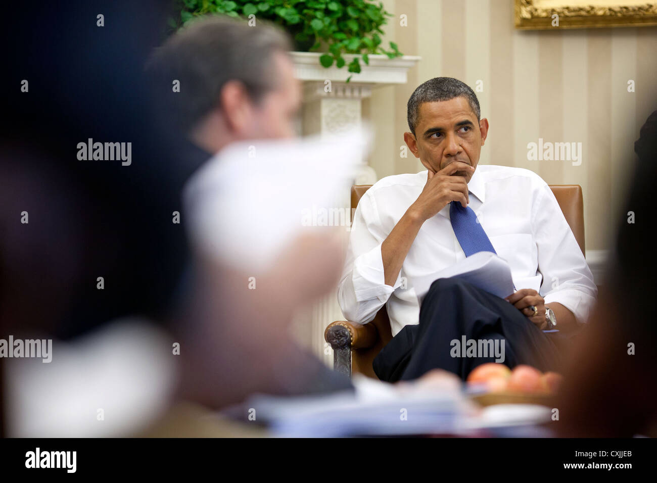 US President Barack Obama meets with staff to discuss ongoing efforts to find a balanced approach to the debt limit and deficit reduction July 11, 2011 in the Oval Office of the White House. Stock Photo