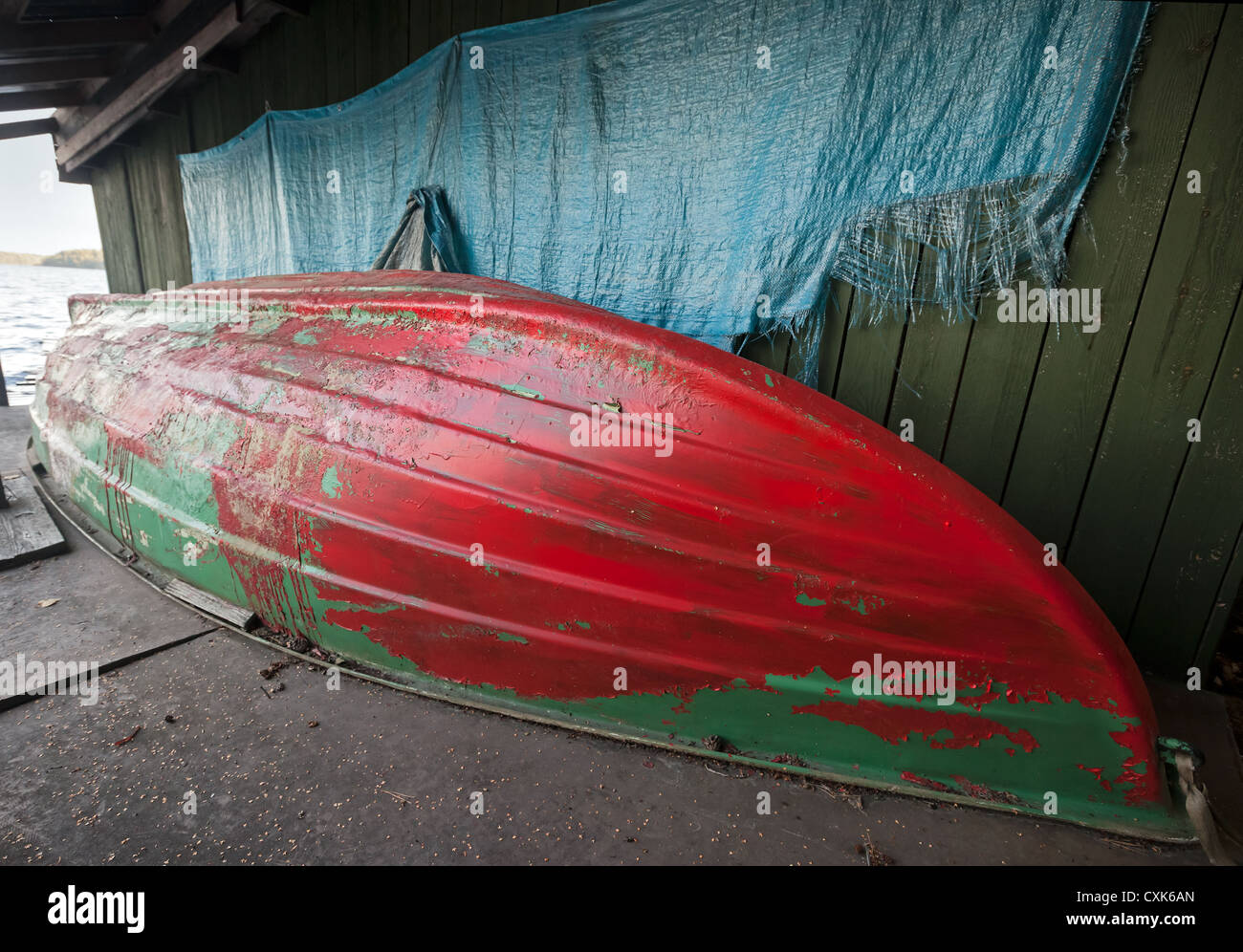 Old rowing fishing boat inverted on the coast under renovation Stock Photo