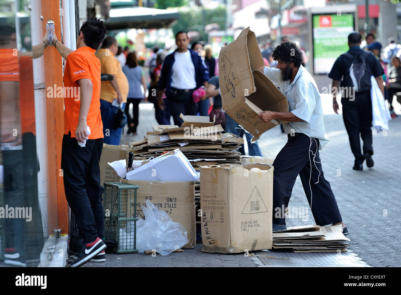 Poor man sorting recyclables or resources, cardboard boxes outside a shop, in order to sell them to a recycling plant Stock Photo