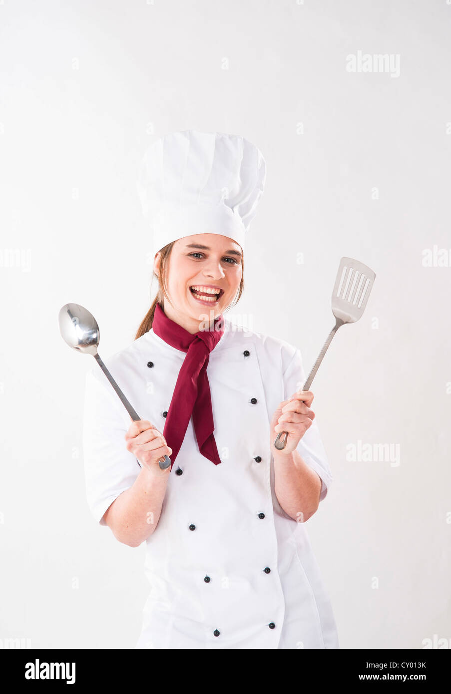 Young chef holding kitchen utensils Stock Photo