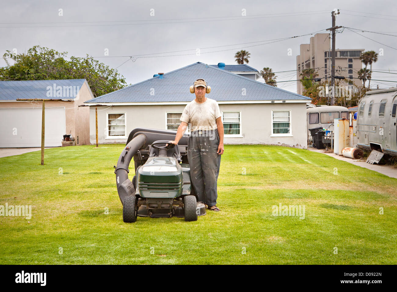 A portrait of a man with his lawnmower. Stock Photo