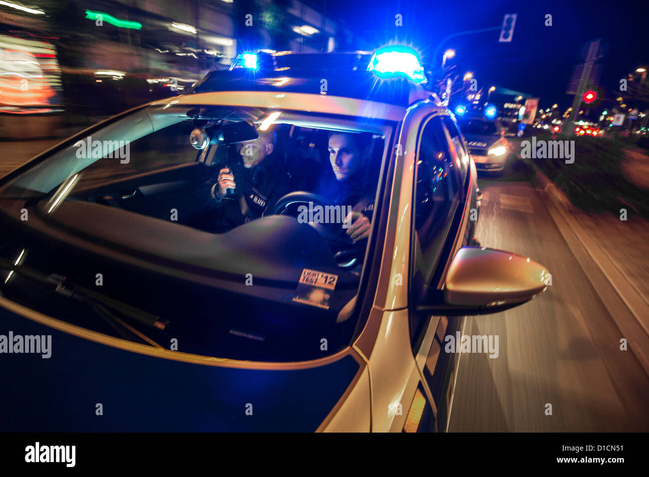 Police patrol car with blue flashing lights, signal horn, driving fast during an emergency mission. Stock Photo