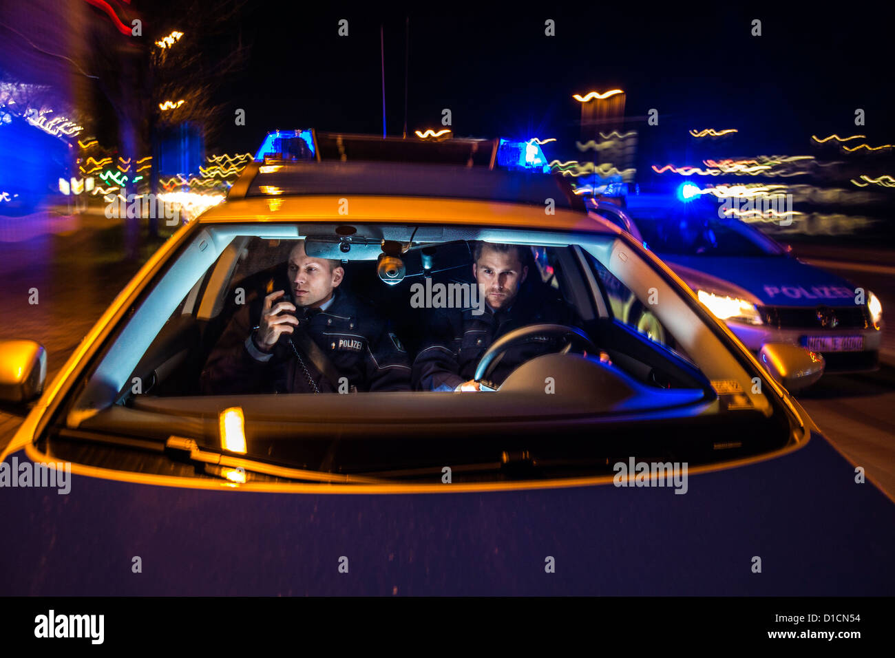 Police patrol car with blue flashing lights, signal horn, driving fast during an emergency mission. Stock Photo