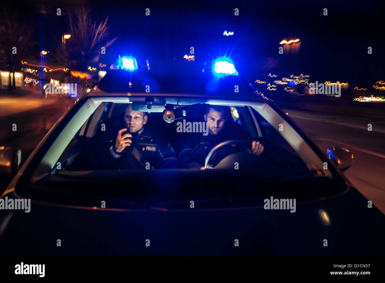 Police patrol car with blue flashing lights, signal horn, driving fast during an emergency mission. Stock Photo