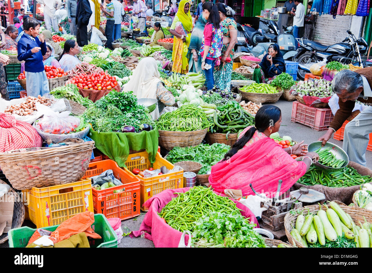 A colorful  fruit and vegetable market in India with local Indian men and women selling and buying on a sunny day Stock Photo