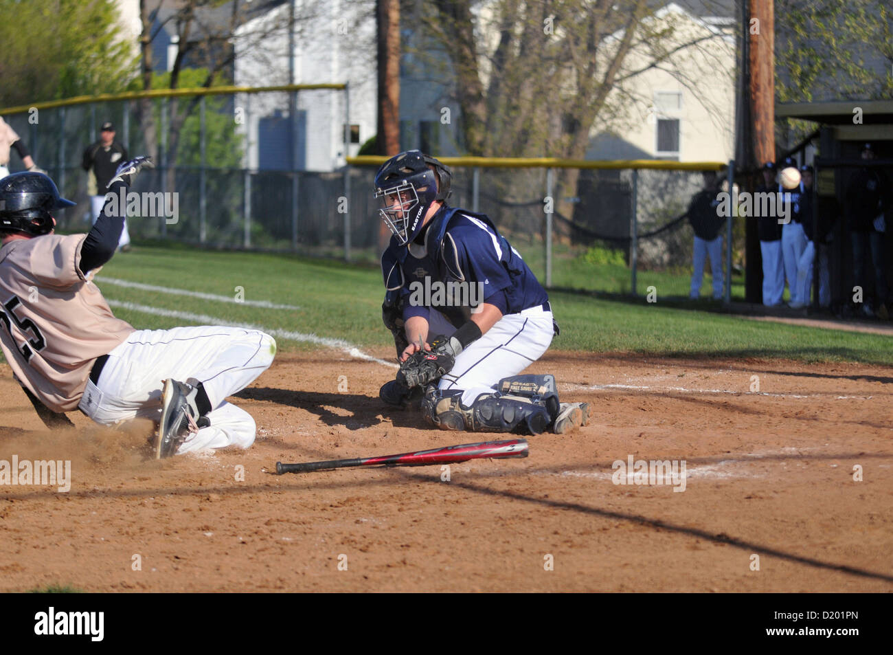 Baseball Sliding base runner safe as the catcher misses ball during a high school game. USA. Stock Photo