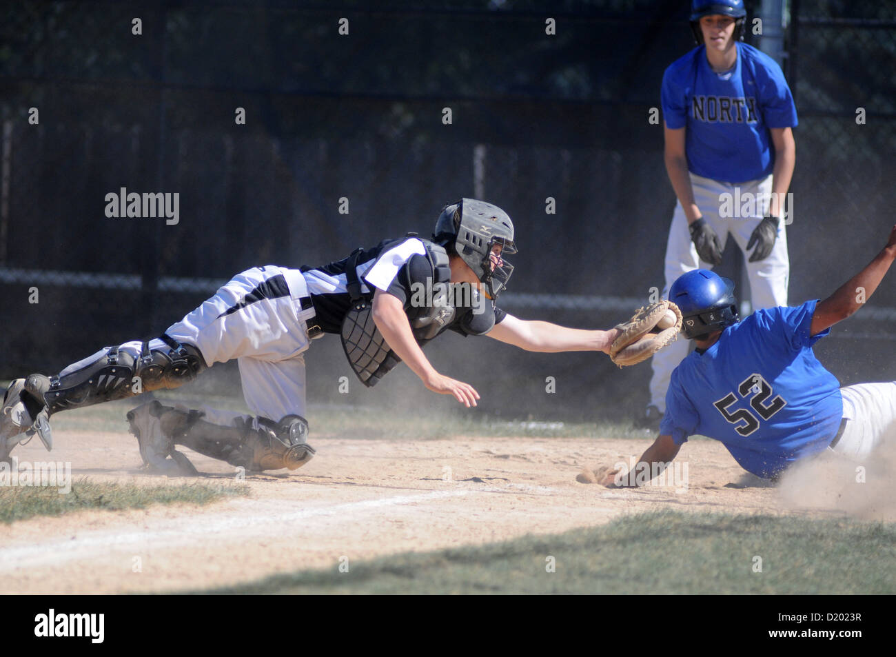 Catcher makes a diving attempt to tag a sliding runner at the plate. USA. Stock Photo