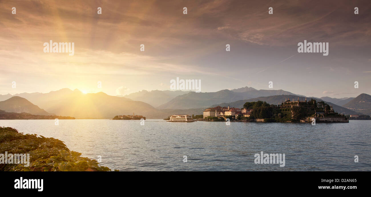 Sun rising over rural village and lake Stock Photo