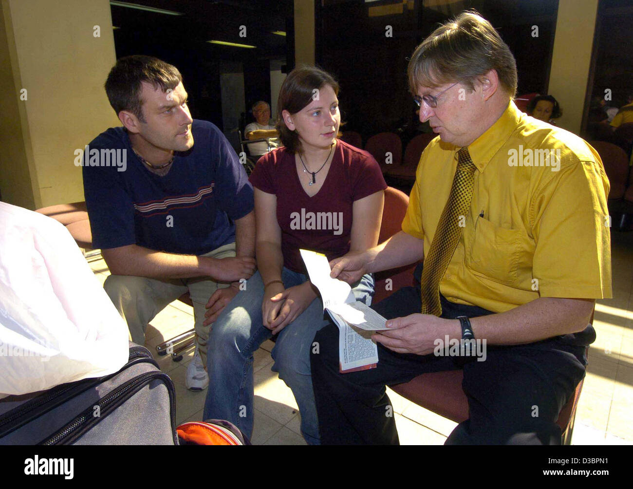 Johannes Domagala (R), employee of the German embassy in Colombo, informs Juliane Hoyer from Leipzig, Germany, and her boyfriend Roberto Stoll about possibilities of returning to Germany at the airport in Colombo, Sri Lanka, Thursday 30 December 2004. The couple survived the bore in Hikkaduwa unhurt Stock Photo