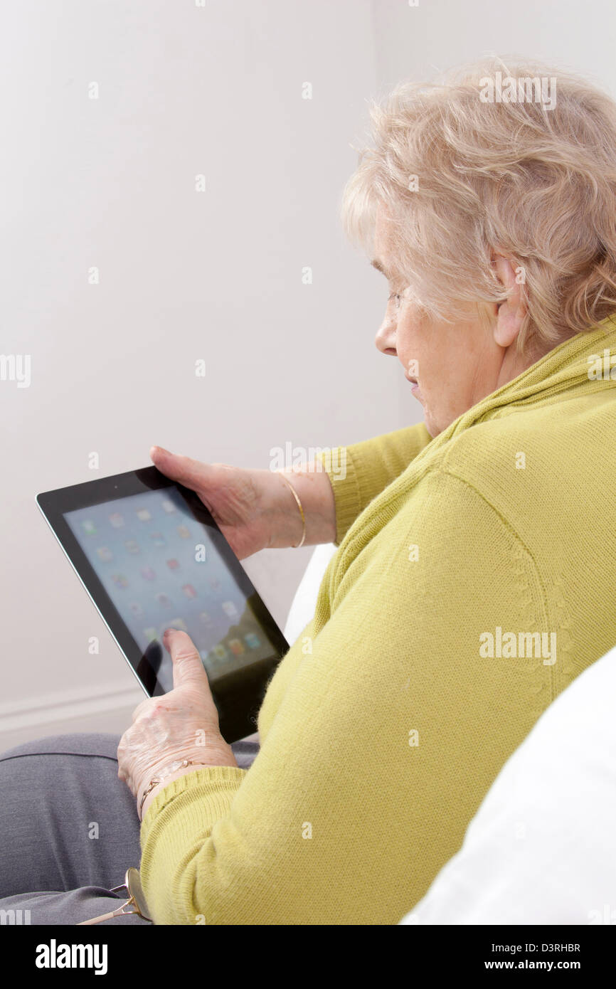 Mature lady using a digital tablet. Stock Photo