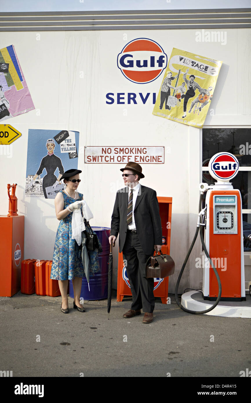 Two visitors to the Goodwood festival dressed in the style of the 1950s in Goodwood, Great Britain, 19 September 2009. Every September, the Earl of March invites to the historic motor racing event Goodwood Revival transforming the country estate to a unique spectacle. The festival is not only a revival of British motor sports history but also a social event for British upper class. Stock Photo