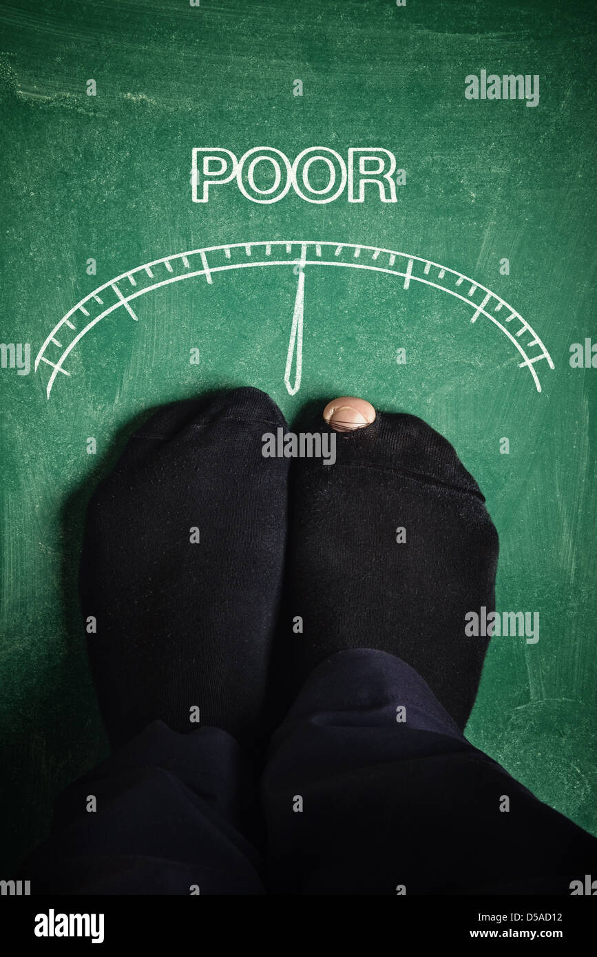 Poor man standing at poverty meter, conceptual image. Stock Photo