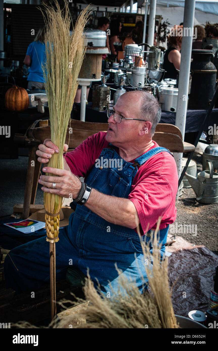 Craftsman assembling handmade brooms. Stock Photo